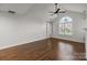 Bright living room featuring wood floors, a ceiling fan, and a large window with natural light at 7502 Hurstbourne Green Dr, Charlotte, NC 28277