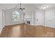 Open concept living room featuring a fireplace, hardwood floors, and plenty of natural light at 7502 Hurstbourne Green Dr, Charlotte, NC 28277
