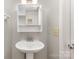 Clean, well-lit bathroom featuring a pedestal sink and a wall-mounted mirror with storage at 7507 Holly Grove Ct, Charlotte, NC 28227