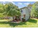 Charming townhome with a brick facade, lush lawn, and a mature tree providing shade at 7507 Holly Grove Ct, Charlotte, NC 28227
