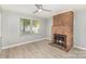 Cozy living room featuring a classic brick fireplace, new flooring and a bright window at 7507 Holly Grove Ct, Charlotte, NC 28227