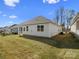 A side view of the home's exterior featuring bright siding and a lush green lawn at 797 Latrobe Dr, Iron Station, NC 28080
