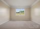 Bright bedroom with neutral carpet, a large window with backyard view, and neutral paint at 797 Latrobe Dr, Iron Station, NC 28080