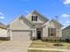 Charming single-story home with beige siding, stone accents, well-manicured lawn, and an attached two-car garage at 797 Latrobe Dr, Iron Station, NC 28080