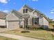 Charming single-story home with beige siding, stone accents, well-manicured lawn, and an attached two-car garage at 797 Latrobe Dr, Iron Station, NC 28080