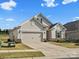 Charming single-story home with beige siding, stone accents, well-manicured lawn, and an attached two-car garage at 797 Latrobe Dr, Iron Station, NC 28080