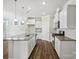 Bright, open kitchen with white cabinets, granite countertops, stainless steel appliances, and hardwood floors at 797 Latrobe Dr, Iron Station, NC 28080