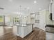 Bright, open kitchen with white cabinets, granite countertops, stainless steel appliances, and hardwood floors at 797 Latrobe Dr, Iron Station, NC 28080