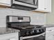 Close-up of stainless steel oven and microwave with white marble backsplash at 797 Latrobe Dr, Iron Station, NC 28080