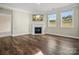 Bright living room featuring dark wood floors, a fireplace with TV, and large windows for ample natural light at 797 Latrobe Dr, Iron Station, NC 28080