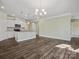 Open-concept living room featuring wood floors, a breakfast bar, and white cabinetry at 797 Latrobe Dr, Iron Station, NC 28080