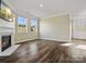 Bright living room featuring dark wood floors, a fireplace with TV, and large windows for ample natural light at 797 Latrobe Dr, Iron Station, NC 28080