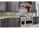Gourmet kitchen showcasing a stainless steel range, custom cabinetry, and mosaic tile backsplash at 802 Capington Ln, Waxhaw, NC 28173