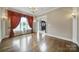 Bright living room featuring hardwood floors, large window with decorative curtains, and an open doorway at 802 Capington Ln, Waxhaw, NC 28173