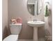 Stylish powder room features a pedestal sink, decorative mirror, and modern fixtures at 8065 Cornhill Ave, Charlotte, NC 28277