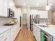 Bright, modern kitchen with white cabinets, stainless steel appliances, and hardwood flooring at 8065 Cornhill Ave, Charlotte, NC 28277