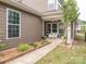 Inviting covered patio with seating, a ceiling fan, and a well-maintained garden and walkway at 8065 Cornhill Ave, Charlotte, NC 28277