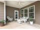 Cozy covered patio with white wicker furniture and ample natural light coming through large windows at 8065 Cornhill Ave, Charlotte, NC 28277