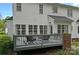View of the white home with large windows overlooking a grey back deck, providing an ideal space for relaxation at 8600 Glade Ct, Huntersville, NC 28078