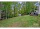 Lush backyard with mature trees, a shed, and an elevated tree house at 8600 Glade Ct, Huntersville, NC 28078