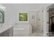 Stylish bathroom with a glass-enclosed shower, soaking tub, and sleek fixtures at 8600 Glade Ct, Huntersville, NC 28078
