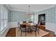 Stylish dining room with patterned wallpaper, hardwood floors, and modern chandelier at 8600 Glade Ct, Huntersville, NC 28078