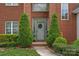 Charming brick home featuring a welcoming front door adorned with elegant shrubbery and lush greenery at 8600 Glade Ct, Huntersville, NC 28078
