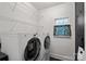 Well-lit laundry room with modern washer and dryer and convenient wire shelving at 8600 Glade Ct, Huntersville, NC 28078