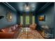 Sophisticated dark-walled living room with bay window, leather sofa, and unique decor at 8600 Glade Ct, Huntersville, NC 28078