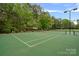 Well-maintained community tennis court with lighting for evening play surrounded by trees at 8600 Glade Ct, Huntersville, NC 28078