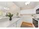 Open kitchen featuring white cabinets and modern appliances, blending seamlessly with the living area at 921 Northeast Dr # 39, Davidson, NC 28036