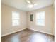 A bright bedroom featuring wood-look floors, a ceiling fan, and two windows at 1011 Rickert St, Statesville, NC 28677