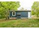 Exterior view of single-story blue home showcasing the side entry door and a small storage shed at 1011 Rickert St, Statesville, NC 28677