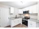 Modern white kitchen featuring stainless steel appliances, granite countertops, and wood-look flooring at 1011 Rickert St, Statesville, NC 28677