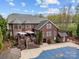 Aerial view of a brick home with a pool, deck, and lush backyard greenery with mature trees at 110 Devonshire Ln, Salisbury, NC 28146