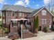 Backyard showing a brick home with a hot tub, deck with umbrellas, and manicured landscaping at 110 Devonshire Ln, Salisbury, NC 28146