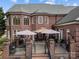 Brick house with multiple windows, covered patio with umbrellas, and well-maintained landscaping at 110 Devonshire Ln, Salisbury, NC 28146