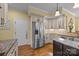 Well-lit kitchen with stainless steel refrigerator, custom cabinetry, and granite countertops at 110 Devonshire Ln, Salisbury, NC 28146