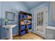Bright laundry room with pedestal sink, shelves with baskets, and access to the backyard through a glass pane door at 110 Devonshire Ln, Salisbury, NC 28146