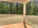 Backyard showcasing a covered porch and large lawn with a backdrop of mature trees at 117 Blackbeard Ln, Mooresville, NC 28117