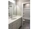 Neutral bathroom featuring white cabinets, quartz countertop, large mirror, and a tub shower combo at 117 Blackbeard Ln, Mooresville, NC 28117