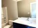 Bright bathroom with a tub, toilet, and navy blue vanity with white countertop and large mirror at 117 Blackbeard Ln, Mooresville, NC 28117