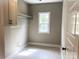 Laundry room features storage cabinet, window for natural light, and tiled flooring at 117 Blackbeard Ln, Mooresville, NC 28117