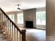Open-concept living room with a fireplace, large windows, and hardwood floors at 117 Blackbeard Ln, Mooresville, NC 28117
