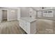 Open kitchen featuring an island with white cabinets and quartz countertops, seamlessly flowing into the living area at 1212 Belmont Circle Dr, Lancaster, SC 29720