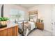 Inviting bedroom with a metal bed frame, neutral-toned walls, and plush carpeting, illuminated by natural light at 153 Pampas Pl, Statesville, NC 28625