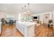 Open-concept kitchen featuring an island with quartz countertops that flows into the dining and living areas with hardwood floors at 153 Pampas Pl, Statesville, NC 28625