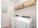 Functional laundry room includes modern washer and dryer, overhead storage and a clean, organized space at 153 Pampas Pl, Statesville, NC 28625