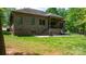A lush green lawn and brick home create a picturesque backyard setting with patio and covered porch at 1590 W 7Th St, Newton, NC 28658