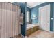 Bathroom featuring a separate shower, soaking tub with tile surround, and a bright white door at 1590 W 7Th St, Newton, NC 28658